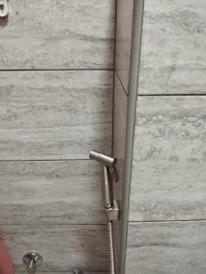 una porta del bagno con una maniglia della doccia su una parete di legno di City villa Bihac a Bihać