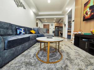 a living room with a couch and a table at Lola's Haven - 75" Screen, Heated Pool, Gym, Views in Nairobi