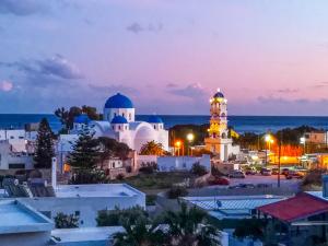 a view of a city at night with a mosque at Villa Dima in Perissa