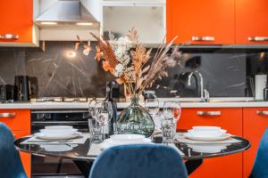 a table with plates and glasses and a vase with flowers at Casa Luce - bright, stylish and central in Modena