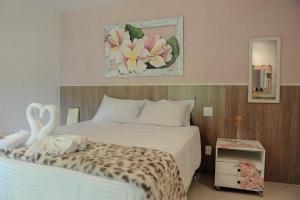 a bedroom with a bed with two swans on it at Pousada Casa Mendes in Guapimirim +13 photos