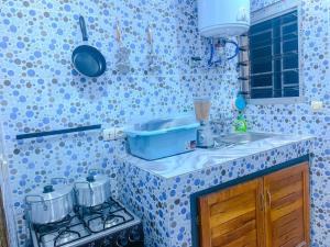 a kitchen with blue and white tiled walls at Havre de vie in Cocody