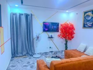 a living room with a couch and a tv at Havre de vie in Cocody