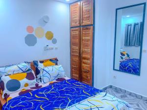 a bedroom with a bed and a large mirror at Havre de vie in Cocody