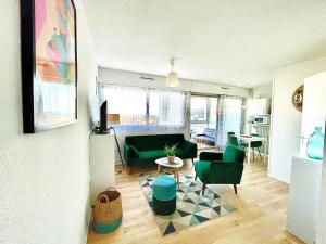 een woonkamer met groene stoelen en een tafel bij Caporizon-Cap239-Vue mer-50m plage in Marillac