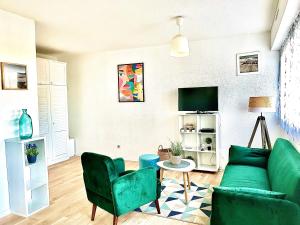 een woonkamer met een groene bank en stoelen bij Caporizon-Cap239-Vue mer-50m plage in Marillac