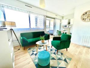 een woonkamer met 2 groene stoelen en een tafel bij Caporizon-Cap239-Vue mer-50m plage in Marillac +12 foto's