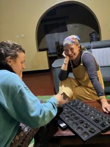 a woman shaking hands with a woman sitting at a table at Bonnie's Homestay 