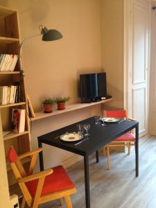 a dining room with a black table and chairs at Côté Saint-Léonard - Honfleur in Honfleur