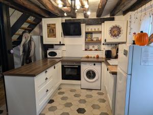 eine Küche mit einem Kühlschrank, einer Waschmaschine und einem Trockner in der Unterkunft La demeure des maraudeurs -10min Disney-Jardin & BBQ in Villiers-sur-Morin