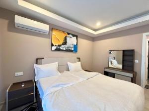 a bedroom with a white bed and a mirror at Elegant 2-Bed Rooms at Kololi Sands in Kololi +6 photos