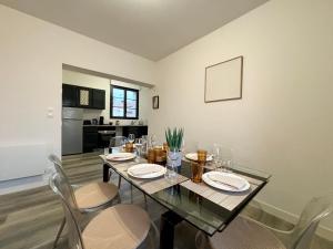 a dining room with a glass table and chairs at Le Corail, Appartement Confort, Centre-ville in La Tremblade +12 photos