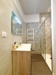 a bathroom with a sink and a shower at Le Corail, Appartement Confort, Centre-ville in La Tremblade