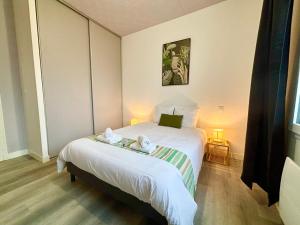 a bedroom with a bed with two towels on it at Le Corail, Appartement Confort, Centre-ville in La Tremblade