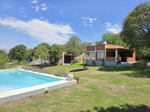 a house with a swimming pool in the yard at Los Molles Suites -Solo 2 Pax- in Mina Clavero