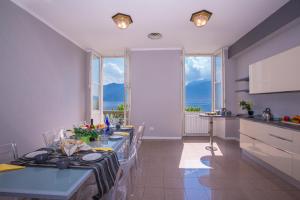 a kitchen and a dining room with a table and some windows at Casa Daniele in Menaggio