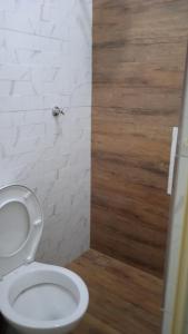 een badkamer met een wit toilet en een houten vloer bij Hotel Maracanã in Sao Paulo