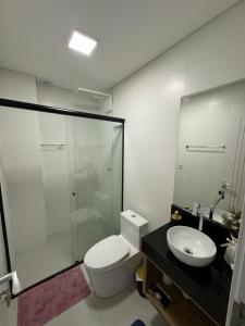 a bathroom with a shower and a toilet and a sink at Flat Home Business 401 Centro de Pomerode in Pomerode