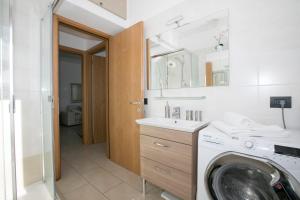Un baño con lavadora y lavabo. en Residence degli Oleandri 1A, en Argegno