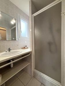 een badkamer met een douche en een wastafel bij L'Océane, studio spacieux avec place de parking, Proche plage in La Palud