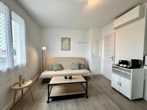 een woonkamer met een bed en een salontafel bij L'Océane, studio spacieux avec place de parking, Proche plage in La Palud +14 foto's