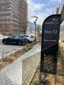 ein Schild vor einem Parkplatz mit Autos in der Unterkunft Mountain Retreat-Modern 1BR w/ Fireplace & Parking in Braşov