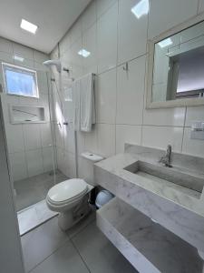 a white bathroom with a sink and a toilet at Vista da Serra. in Gramado +48 photos