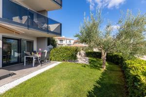 een huis met een tuin met een tafel en een boom bij Apartment Elegance in Krk