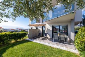 een huis met een tafel en stoelen in een tuin bij Apartment Elegance in Krk +40 foto's