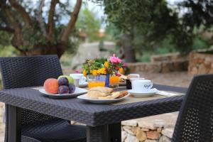 a table with a breakfast of fruit and coffee on it at B&B Lu Cantoru in Marina di Pescoluse