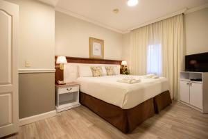 Rúm í herbergi á Hotel Villa Morra Suites