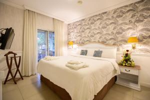 Rúm í herbergi á Hotel Villa Morra Suites