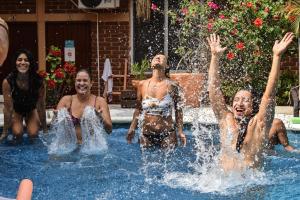 a group of people playing in a swimming pool at Casa Losodeli & Coworking- Adults Only in Puerto Escondido