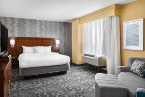 um quarto de hotel com uma cama e um sofá em Courtyard by Marriott Newark Downtown em Newark mais 26 fotografias
