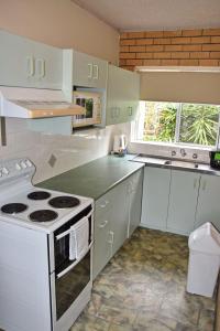 La cocina está equipada con electrodomésticos blancos y fogones. en Wards Holiday Flat 2, en South West Rocks