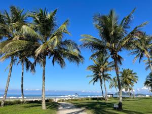 a row of palm trees on the beach at FLAT RIVIERA NOVINHO A 150m DA PRAIA ! in Riviera de São Lourenço