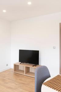 a flat screen tv sitting on a stand in a living room at LE 23 Bis in Jarny