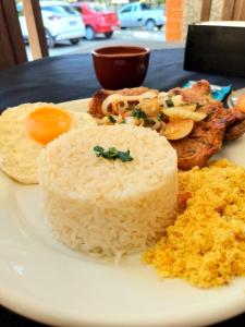 un plato de comida con arroz y una naranja en una mesa en Chalé Hospedagem Ecológica, en Ribeirão Pires