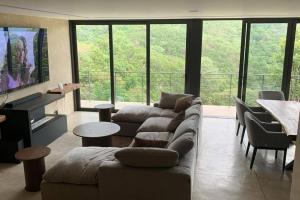 a living room with a couch and a tv at Espectacular casa con hermosa vista al lago - El Santuario Resort in Colorines