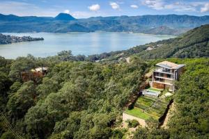 an aerial view of a house on a hill next to a lake at Espectacular casa con hermosa vista al lago - El Santuario Resort in Colorines