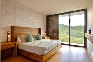 a bedroom with a large bed and a large window at Espectacular casa con hermosa vista al lago - El Santuario Resort in Colorines +33 photos