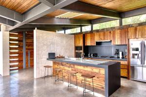 a kitchen with a large counter with stools in it at Espectacular casa con hermosa vista al lago - El Santuario Resort in Colorines