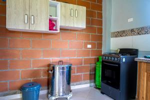 een keuken met een bakstenen muur en een fornuis bij Finca San Rafael cerca al rio Wifi 6-12 personas in San Rafael