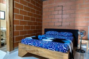 een bed in een kamer met een bakstenen muur bij Finca San Rafael cerca al rio Wifi 6-12 personas in San Rafael