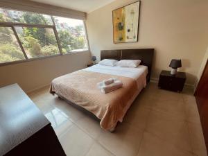 a bedroom with a bed with two towels on it at Gallery Suite en Riverfront Puerto Santa Ana in Guayaquil