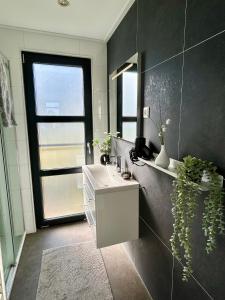 a bathroom with a sink and a mirror and a window at Enkhuizer Strand Chalet WolkeSieben Dritte Reihe mit Zaun Hausnr 202 in Enkhuizen