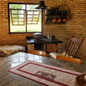 a kitchen with a table and chairs and a table and a window at Casa de campo in Treze de Maio
