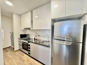 eine Küche mit einem Kühlschrank aus Edelstahl und einer Spüle in der Unterkunft Apartamento Lujoso y Comodo con la mejor vista panoramica de Santa Cruz in Hamacas