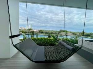 eine Hängematte in einem Raum mit einem großen Fenster in der Unterkunft Apartamento Lujoso y Comodo con la mejor vista panoramica de Santa Cruz in Hamacas