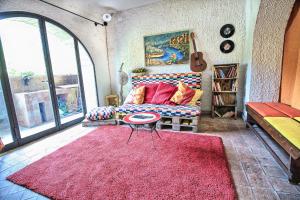 sala de estar con sofá y alfombra roja en La Tavernetta, en Santa Venerina